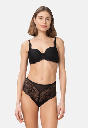 Zwarte kanten beha met gewatteerde cups en verstelbare bandjes, gecombineerd met zwarte kanten slips met hoge taille, voorzien van bloemmotieven en doorschijnende panelen.