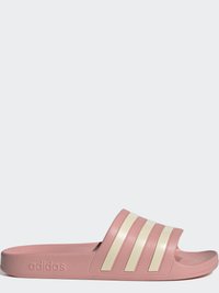 Ružové šľapky na podrážke z textúrovaného gumového materiálu s tromi bielymi horizontálnymi pruhmi a vyrazeným logom na boku. Dizajn so hladkou pätou.