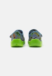 Back view of blue shoes featuring colorful dinosaur patterns. The sole is green, with a textured finish and a pull tab on the heel.