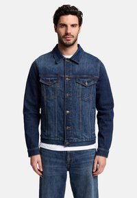 Giacca in denim di colore indaco scuro con due tasche sul petto, bottoni argentati e colletto standard. Progettata con maniche lunghe e una vestibilità regolare.