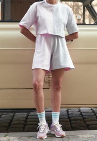 Ljust rosa och grått kortärmad t-shirt, matchad med grå shorts. Vita strumpor med ljusblå ränder och rosa sneakers.