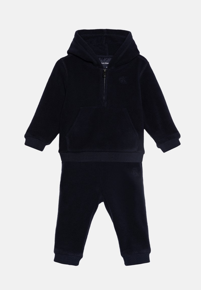 Chándal de forro polar azul marino con sudadera con cremallera, bolsillo frontal y puños de canalé. Incluye pantalones jogger a juego con cinturilla elástica.