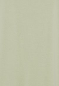 Texture de tissu vert clair uni avec un motif tissé subtil et des plis doux.