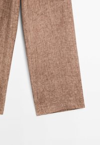 Pantalon large marron en tissu doux et texturé présenté sur fond blanc.