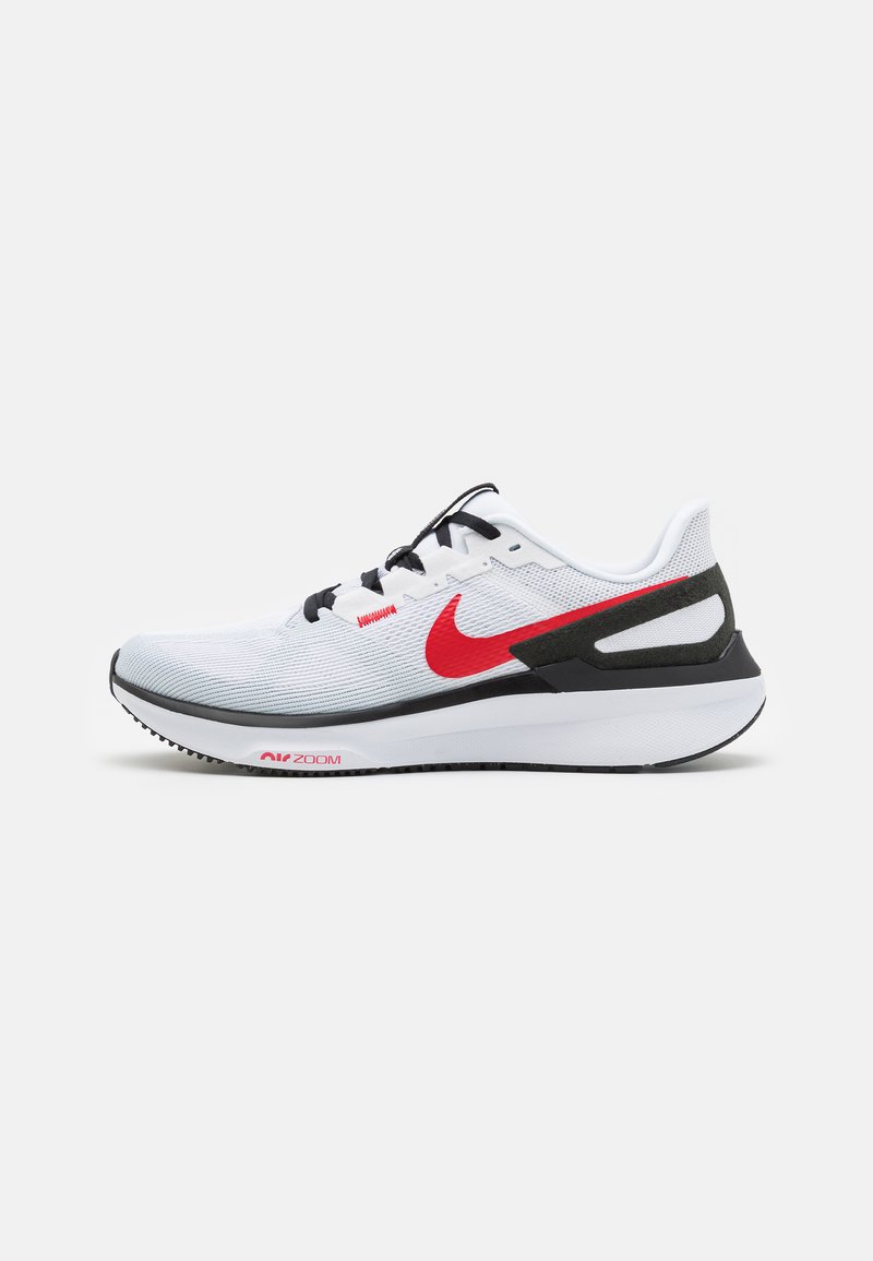 Sportska cipela od bijele mrežice s crnim naglasima, crvenim swoosh logotipom i mekanim bijelim potplatom, s teksturiranim gornjim dijelom i vidljivim zračnim jastučićem.