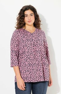 Roze top met een donker panterprintpatroon, v-hals, driekwart mouwen en geplooide details. Gekocht met donkerblauwe jeans.