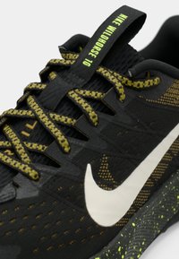 Nike Wildhorse 10 παπούτσι τρεξίματος σε μαύρο χρώμα με πράσινες λεπτομέρειες, διαθέτει υφασμάτινο άνω μέρος, μοτίβο στις κορδόνες και χαρακτηριστικό λευκό λογότυπο.