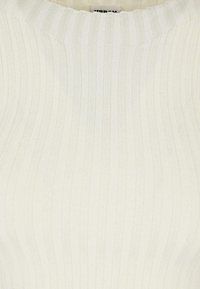 Geribbelde gebreide top in off-white met een ronde halslijn. Heeft verticale strepen en een gladde textuur. Etiket zichtbaar in het nekgebied.