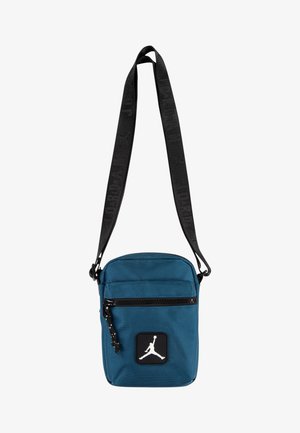 Bolso bandolera en color verde azulado, hecho de tela texturizada, con cierre de cremallera negro, correa ajustable y un logo Jumpman blanco en un parche negro.
