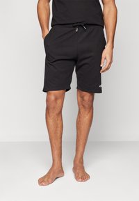 Zwarte sportieve shorts met een elastische tailleband en trekkoord, zijzakken en een gladde textuur.