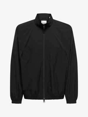 Veste noire légère zippée avec poignets et ourlet élastiques, col montant et détails discrets de coutures sur la poitrine et les épaules.