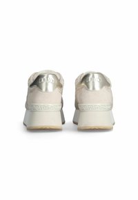 Vaaleanbeiget lenkkitossut, joissa on teksturoitu mokkanahkainen päällinen, hopeanväriset metallikoristeet ja koristeellinen valkoinen kuvio lohkokorkokengässä.