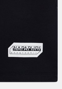 Zwarte stof met een gestructureerde afwerking, voorzien van een wit rechthoekig logo-label met de tekst "NAPAPURI geographic" in vette zwarte letters.