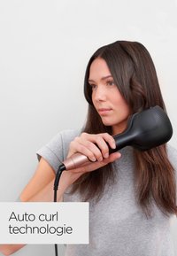 Auto curling hair tool with a black ergonomic head and rose gold textured handle. Corded design with a flexible power cord.