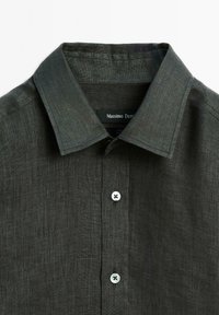 Donkergrijze linnen overhemd met een verspreide kraag, voorzien van een knoopsluiting aan de voorkant en twee witte knopen. Label: Massimo Dutti.