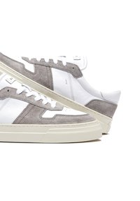 Sneakers in suede grigio e pelle bianca con suola testurizzata e accenti in contrasto. Presentano lacci piatti e un design moderno.
