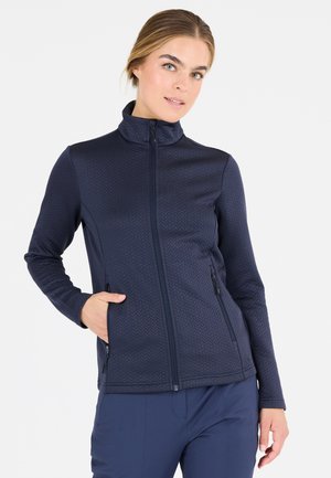 Mørkeblå zip-up jakke lavet af tekstureret stof med høj krave, prydet med to sidelommer og et chevron-mønster.
