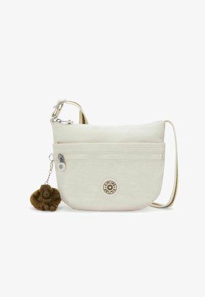 Kleine beige crossbodytas met voorrits vak, ronde logopatch, verstelbare band en een eraan bevestigde bruine pluche apensleutelhanger.