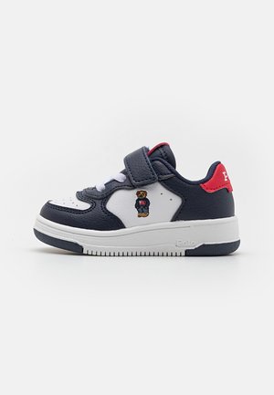 Dziecięce niskie sneakersy w kolorze granatowym, białym i czerwonym z paskiem na rzep oraz małym haftowanym misiem po boku.