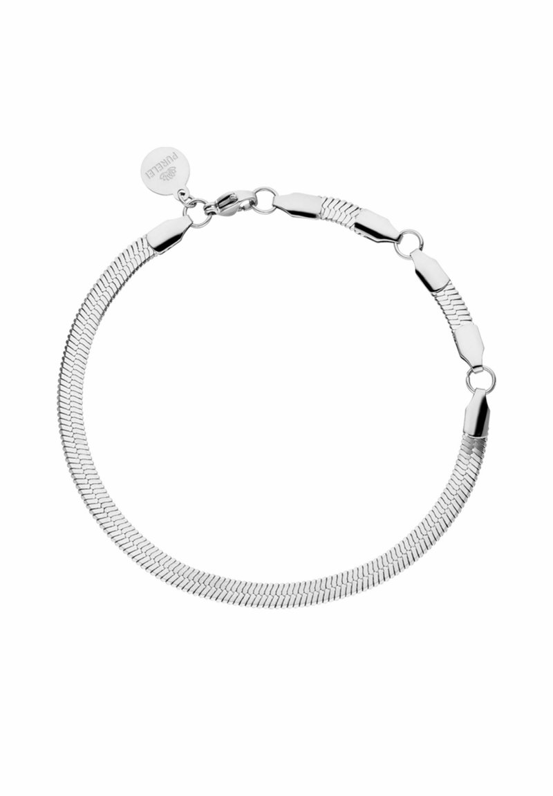 Bracelet chaîne en argent avec des maillons plats tissés, fermoir mousqueton et une médaille ronde gravée du nom de la marque.