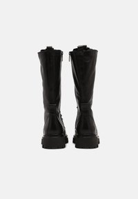 Botas de cuero negras hasta la rodilla con una textura suave, cremalleras laterales y suelas de goma gruesas, que presentan un diseño simple sin adornos.