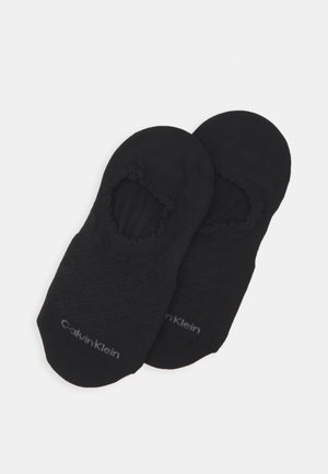 Melnas neredzamās zeķes, kas izgatavotas no mīksta auduma, ar strukturētu dimanta rakstu, elastīgām atverēm un subtilu Calvin Klein zīmolu.