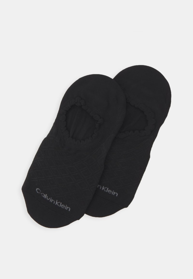 Meias invisíveis pretas feitas de tecido macio, com um padrão de diamante texturizado, aberturas elásticas e uma discreta marca Calvin Klein.