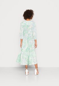 Vestido floral de longitud media en una tela ligera y translúcida con manchas verdes y azules; cuenta con mangas abullonadas y una falda en capas.