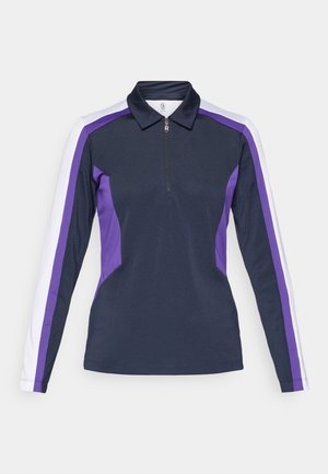 Polo a maniche lunghe in navy con pannelli laterali viola e bianchi, dotato di colletto con zip e un design sportivo e aderente. Tessuto dalla consistenza liscia.