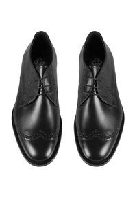 Chaussures habillées en cuir noir, avec un bout arrondi, un laçage, un décor en brogue le long des coutures et une texture lisse.
