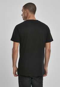 Sort kortærmet t-shirt lavet af bomuld, med en klassisk rund hals og lige snit. Glat tekstur, minimalistisk design, uden grafik eller accenter.