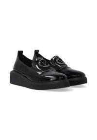 Černé lakované slip-on boty s kulatou špičkou, zdobené dekorativním studeným designem na přední části a silnou ribbovanou platformou.