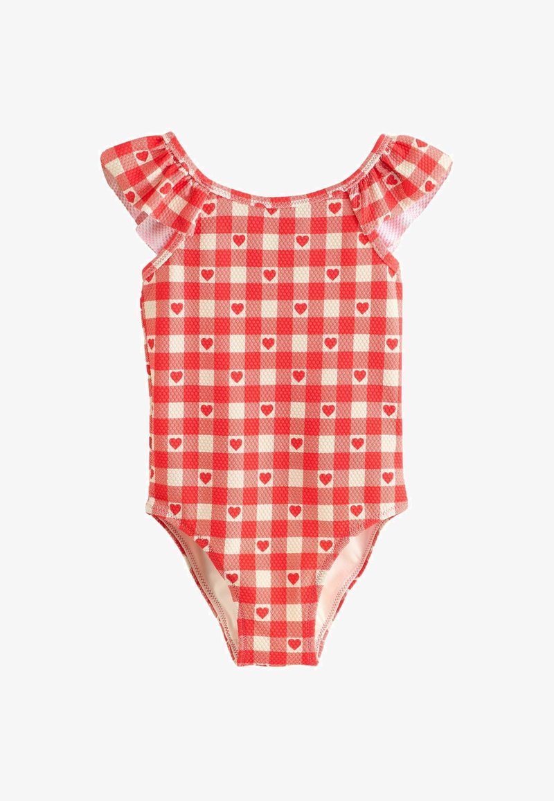 Une combinaison de bain une pièce à carreaux rouges et blancs avec des manches volantées, ornée de petits motifs en forme de cœur, fabriquée en tissu extensible.