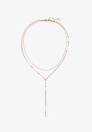 Collier superposé en or rose avec des chaînes fines, présentant un accent en goutte allongée et de petites perles rondes espacées le long des brins.
