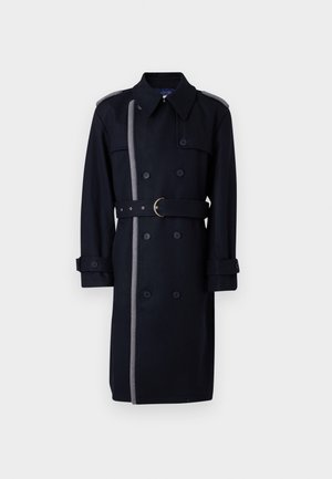 Črni volneni plašč s dvojno zapenjanjem, s sivim stranskim trakom, pasom z medeninasto sponko in gumbnimi manšetami.