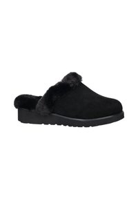 Zwarte suede klompen met een fluffy zwarte nepbont afwerking. Dikke zwarte rubberen zool met een gestructureerd patroon voor grip. Rond toelopend ontwerp.