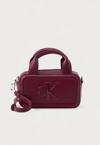 Burgundy synthetic leather handbag with two short handles, a removable shoulder strap, a zip closure, and embossed logo on the front.