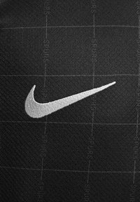 Tessuto nero con un motivo a griglia caratterizzato da un prominente logo ricamato Nike swoosh bianco sul lato sinistro. Finitura texture.