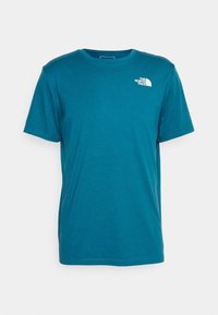 Teal bomull t-shirt med korta ärmar, rund hals och The North Face-logotyp i vitt på vänster bröst. Slät textur, avslappnad passform.