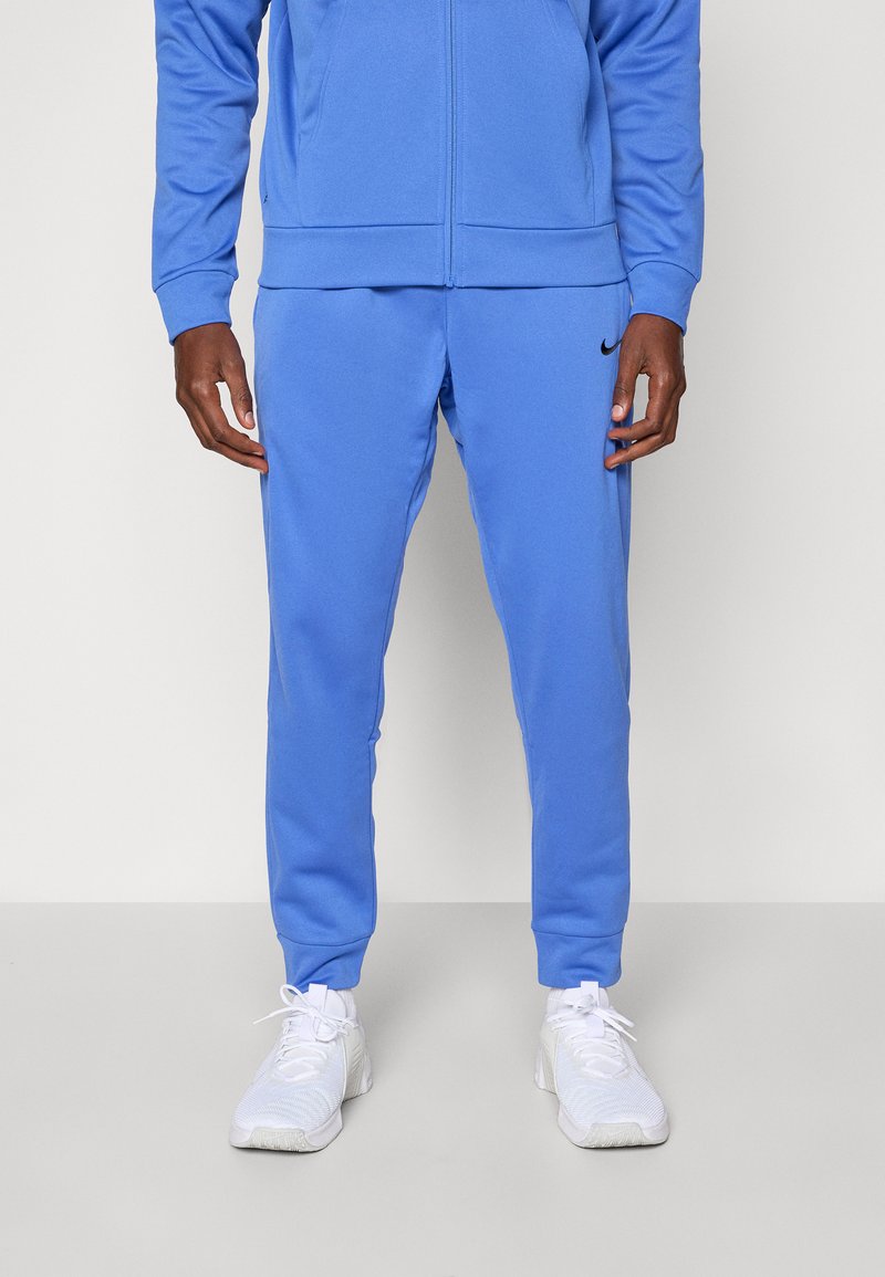Blue athletic tracksuit featuring a zip-up jacket and tapered pants. Made from soft fabric with ribbed cuffs; includes a small Nike logo.