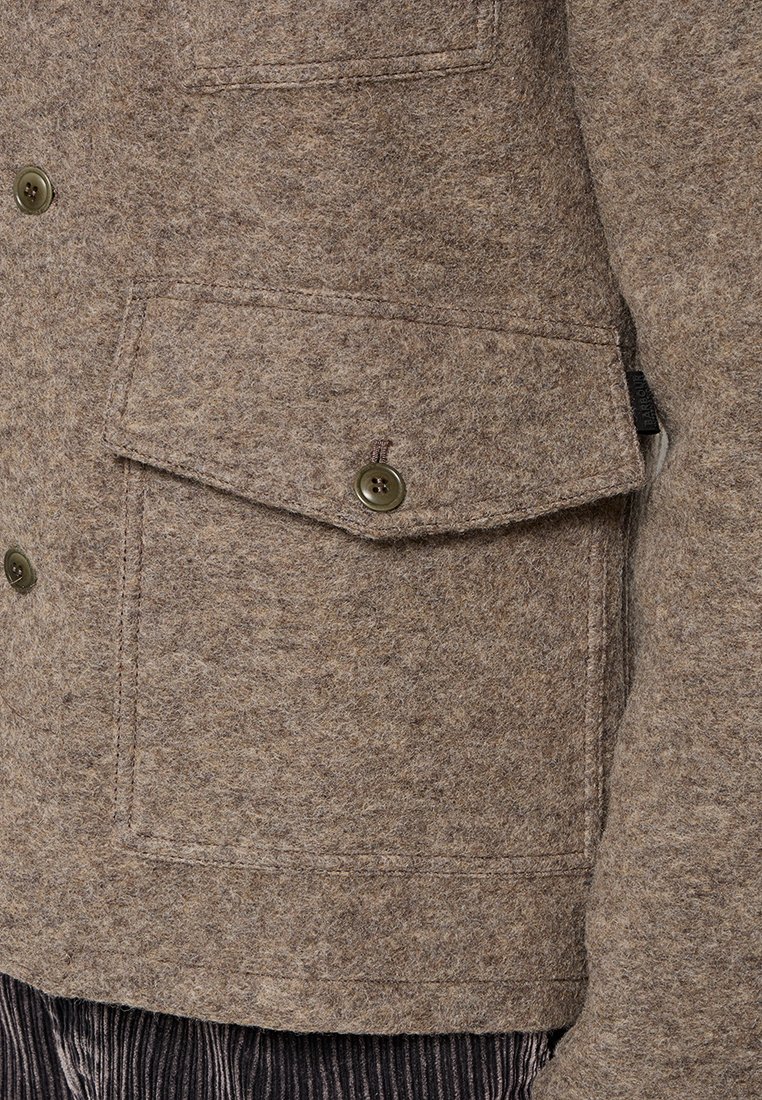 Braune Filzjacke mit geknöpftem Vorderteil und einer großen Klappentasche. Das Material hat eine strukturierte Oberfläche mit subtilen Farbvariationen.