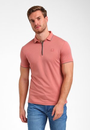 Polo de manga corta en rosa empolvado con cuello con cremallera, ribete en contraste y un pequeño logo en el pecho. Tela suave y diseño ajustado.