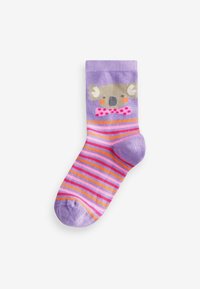 Lila strumpor med en koala-grafik som har en rosa fluga. Randigt mönster i rosa, orange och lavendelfärger. Mjuk tygtextur.