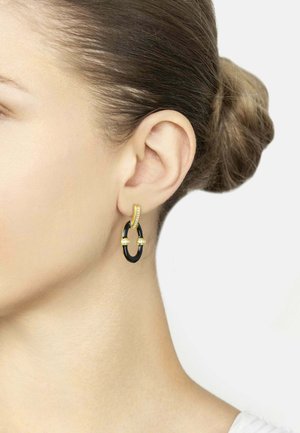 Gold and black hoop earrings with a curved design, featuring a textured gold accent and two small golden bands on a black surface.