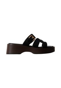 Sandale à plateforme noire avec trois brides, dont une avec une boucle dorée, et une semelle épaisse marron foncé avec une légère découpe au niveau de la voûte plantaire.
