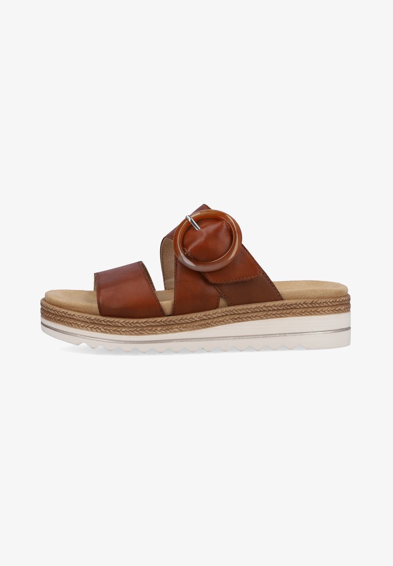 Brown leather slide sandal with two wide straps, circular accent, and textured midsole. Thick, white rubber sole with patterned tread.