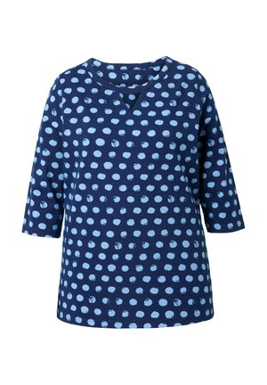 Camisa de manga larga color azul marino con lunares irregulares en azul claro y una pequeña muesca en forma de V en el cuello redondo.