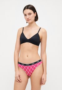 Svart, trekantet bralette med justerbare stropper og matchende rosa mønstrede truser med en svart logo-livlinje. Glatt stofftekstur.