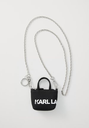 Svart tyg mini-väska med silverkedjehandtag, med ett övre handtag, dragkedjestängning och stor vit logotyp på framsidan.
