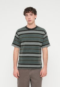 Κοντομάνικο ριγέ t-shirt με οριζόντιες ρίγες σε σκούρο πράσινο, μαύρο, λευκό και κίτρινο χρώμα· στρογγυλή λαιμόκο ψη· απαλό ύφασμα.